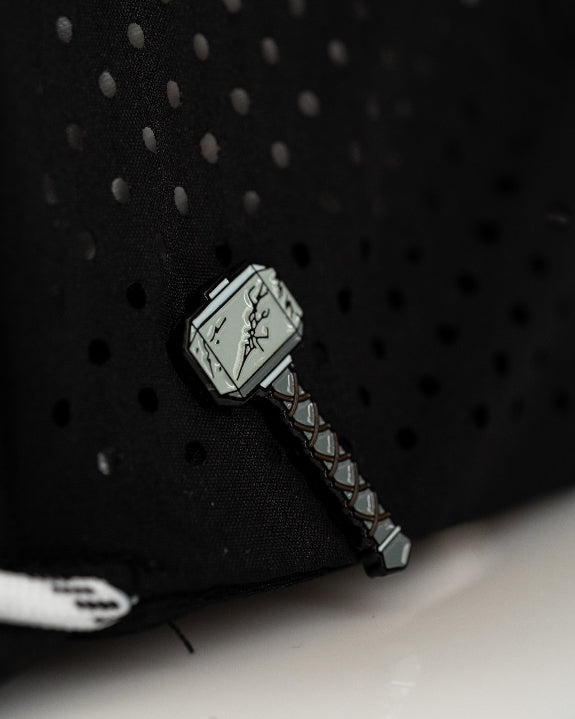 Thor’s Hammer Black perforated rope golf hat by Pins & Aces featuring a hammer-inspired design, adjustable snapback, breathable perforations, and built-in magnetic ball marker holder.