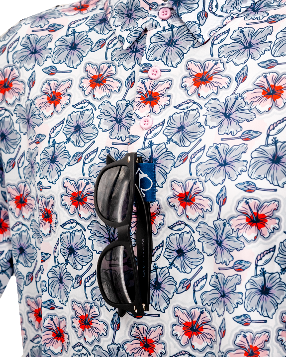 Men’s Hibiscus Harmony golf polo by Pins & Aces featuring blue and coral hibiscus flowers on a white lightweight performance golf shirt.