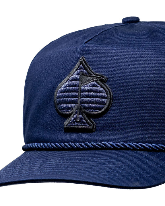 Heritage Navy rope golf hat by Pins & Aces featuring a low-profile 5-panel design, rope accent, adjustable snapback, and built-in magnetic golf ball marker holder.