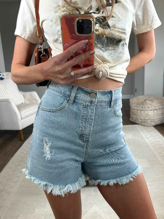 Brooke High Waisted Denim Shorts featuring a flattering high-rise waist, premium stretch denim, subtle distressed details, classic five-pocket styling, and a frayed hem for an effortless boutique summer look. Comes in a Light Wash