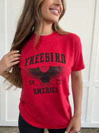 Women’s Freebird 1973 graphic tee featuring a bold Freebird America design, bald eagle graphic, black detailing, and vintage-inspired artwork on a Comfort Colors® cotton T-shirt in Red