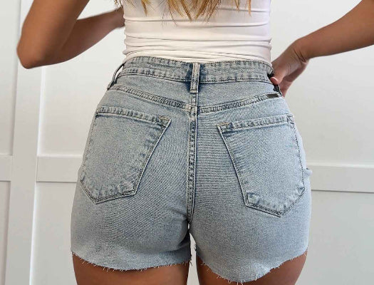 Mazie Asymmetrical Raw Hem Denim Shorts in Light Wash