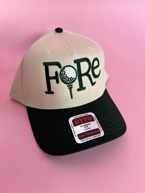 FORE women’s golf trucker hat featuring bold FORE lettering, a breathable mesh back, curved bill, and adjustable snapback closure.