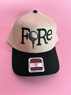 FORE women’s golf trucker hat featuring bold FORE lettering, a breathable mesh back, curved bill, and adjustable snapback closure.