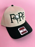 FORE women’s golf trucker hat featuring bold FORE lettering, a breathable mesh back, curved bill, and adjustable snapback closure.