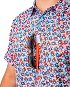 Men’s Bomb Pop Splatter golf polo by Pins & Aces featuring an all-over red, white, and blue splatter pattern with short sleeves and an athletic performance fit.