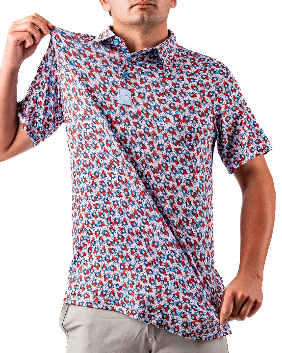 Men’s Bomb Pop Splatter golf polo by Pins & Aces featuring an all-over red, white, and blue splatter pattern with short sleeves and an athletic performance fit.