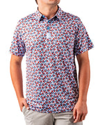 Men’s Bomb Pop Splatter golf polo by Pins & Aces featuring an all-over red, white, and blue splatter pattern with short sleeves and an athletic performance fit.