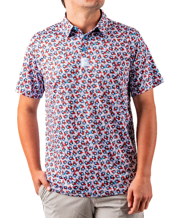 Men’s Bomb Pop Splatter golf polo by Pins & Aces featuring an all-over red, white, and blue splatter pattern with short sleeves and an athletic performance fit.