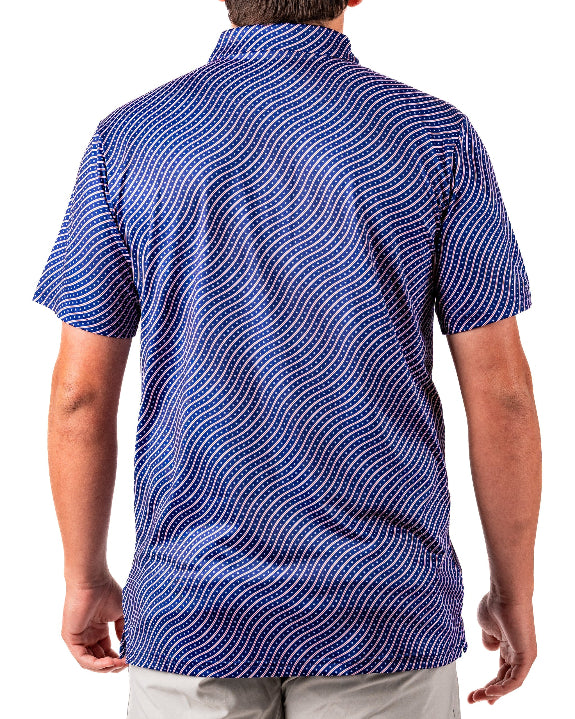 Men’s Wavy Stars & Stripes golf polo by Pins & Aces featuring a navy, red, and white wavy patriotic pattern with short sleeves and an athletic performance fit.
