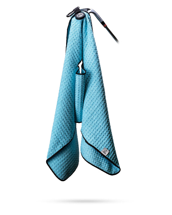 Sky blue Pins & Aces magnetic golf towel featuring waffle-knit fabric, a strong built-in magnet, center slit, and carabiner for attaching to a golf bag.