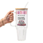 Clear glass cup with bamboo lid and straw featuring pink Booktrovert lettering, a definition about preferring fictional characters to real people, and an open book filled with pink and purple flowers.