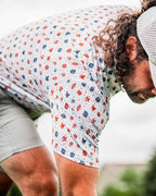 Pins & Aces American Traditional men’s golf polo featuring a bold patriotic Americana and classic tattoo flash-inspired design with an athletic performance fit.