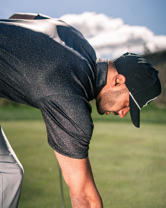 Men’s Man’s Best Friend Dark golf polo by Pins & Aces featuring a subtle dog-inspired pattern on a dark charcoal performance polo with short sleeves and athletic fit.