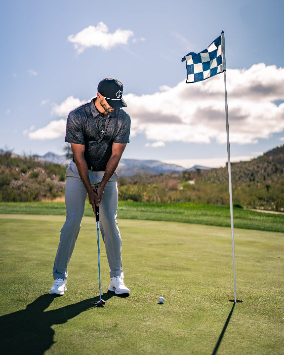 Men’s Man’s Best Friend Dark golf polo by Pins & Aces featuring a subtle dog-inspired pattern on a dark charcoal performance polo with short sleeves and athletic fit.