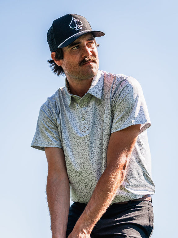 Men’s Man’s Best Friend Light golf polo by Pins & Aces featuring a subtle dog-inspired micro print in light blue and white with short sleeves and an athletic performance fit.