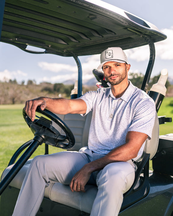 Men’s Man’s Best Friend Light golf polo by Pins & Aces featuring a subtle dog-inspired micro print in light blue and white with short sleeves and an athletic performance fit.