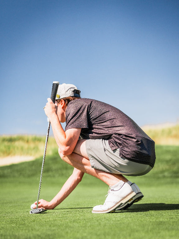 Men’s Man’s Best Friend Dark golf polo by Pins & Aces featuring a subtle dog-inspired pattern on a dark charcoal performance polo with short sleeves and athletic fit.