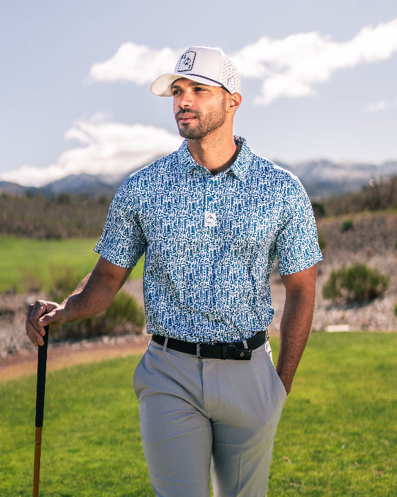 Men’s Maze Craze golf polo by Pins & Aces featuring an all-over blue maze-inspired geometric pattern with short sleeves and an athletic performance fit.