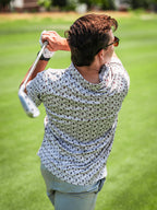 Men’s Retro Form golf polo by Pins & Aces featuring a vintage-inspired geometric print in neutral tones with burgundy accents, short sleeves, and an athletic fit.