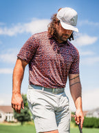Men’s Shadow Rose golf polo by Pins & Aces featuring an all-over red and muted rose floral print on a black background with short sleeves and an athletic performance fit.