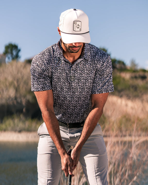 Men’s Shark Tooth golf polo by Pins & Aces featuring an all-over black, charcoal, gray, and white shark tooth-inspired micro print with short sleeves and an athletic performance fit.
