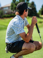 Pins & Aces Signal Boost men’s performance golf polo featuring an athletic fit with breathable fast-wicking fabric, SPF 45+ protection, and built-in sunglasses holder.