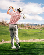 Men’s Soft Spoken golf polo by Pins & Aces featuring a subtle coral, red, navy, and white micro floral print with short sleeves and an athletic performance fit.