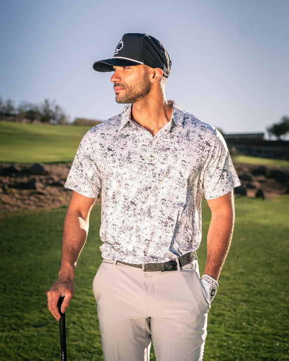 Men’s White Noise golf polo by Pins & Aces featuring a subtle white and gray abstract pattern, short sleeves, and an athletic performance fit.
