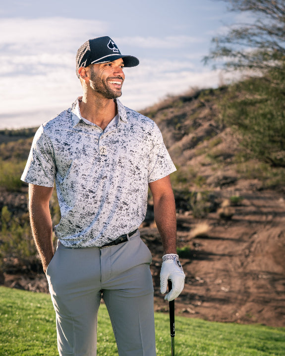 Men’s White Noise golf polo by Pins & Aces featuring a subtle white and gray abstract pattern, short sleeves, and an athletic performance fit.