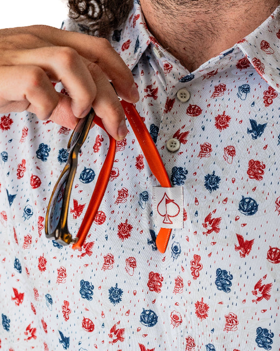 Pins & Aces American Traditional men’s golf polo featuring a bold patriotic Americana and classic tattoo flash-inspired design with an athletic performance fit.