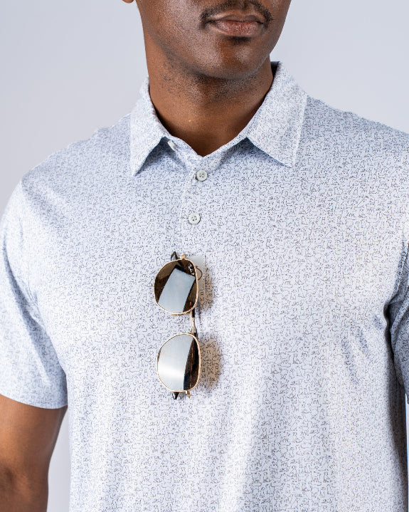 Men’s Man’s Best Friend Light golf polo by Pins & Aces featuring a subtle dog-inspired micro print in light blue and white with short sleeves and an athletic performance fit.