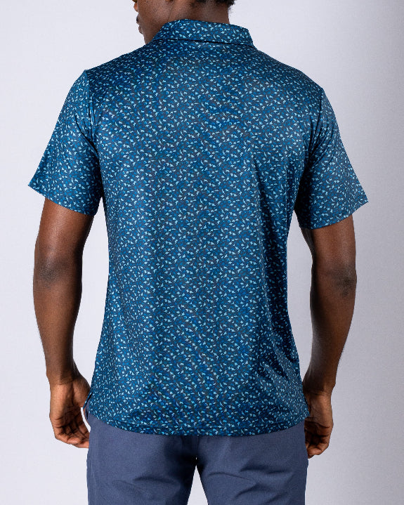 Men’s Manta Ray golf polo by Pins & Aces featuring a deep ocean blue all-over aquatic-inspired pattern, short sleeves, collared neckline, and athletic performance fit.