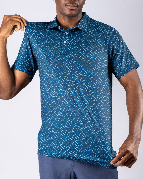 Men’s Manta Ray golf polo by Pins & Aces featuring a deep ocean blue all-over aquatic-inspired pattern, short sleeves, collared neckline, and athletic performance fit.