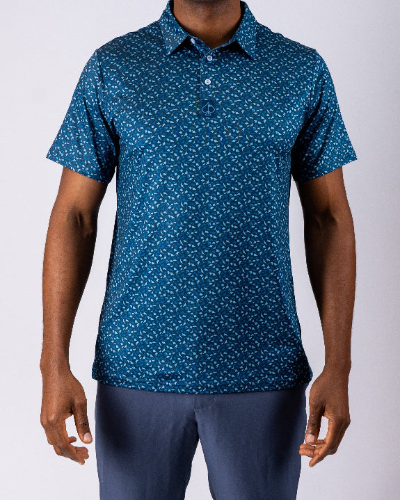 Men’s Manta Ray golf polo by Pins & Aces featuring a deep ocean blue all-over aquatic-inspired pattern, short sleeves, collared neckline, and athletic performance fit.