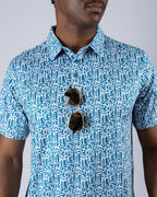 Men’s Maze Craze golf polo by Pins & Aces featuring an all-over blue maze-inspired geometric pattern with short sleeves and an athletic performance fit.