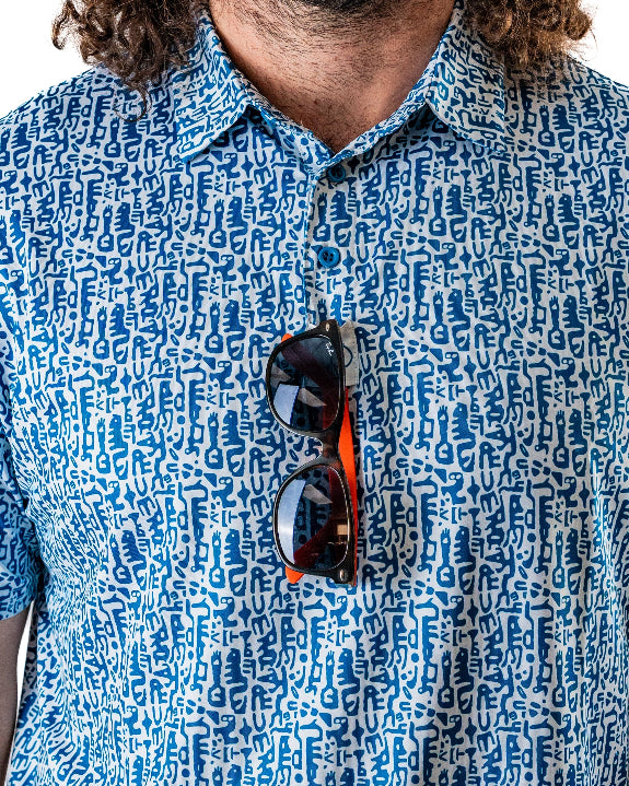 Men’s Maze Craze golf polo by Pins & Aces featuring an all-over blue maze-inspired geometric pattern with short sleeves and an athletic performance fit.