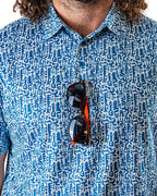Men’s Maze Craze golf polo by Pins & Aces featuring an all-over blue maze-inspired geometric pattern with short sleeves and an athletic performance fit.