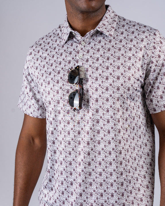 Men’s Retro Form golf polo by Pins & Aces featuring a vintage-inspired geometric print in neutral tones with burgundy accents, short sleeves, and an athletic fit.