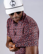 Men’s Shadow Rose golf polo by Pins & Aces featuring an all-over red and muted rose floral print on a black background with short sleeves and an athletic performance fit.