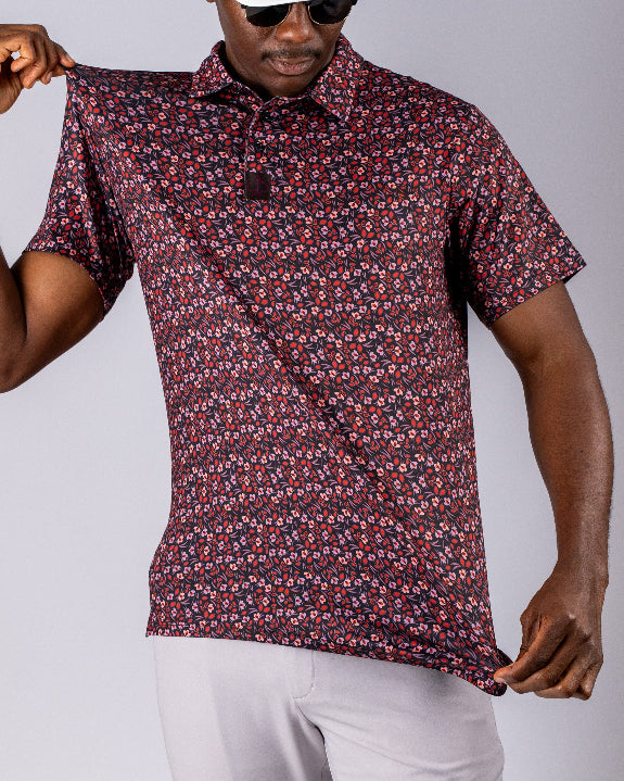 Men’s Shadow Rose golf polo by Pins & Aces featuring an all-over red and muted rose floral print on a black background with short sleeves and an athletic performance fit.