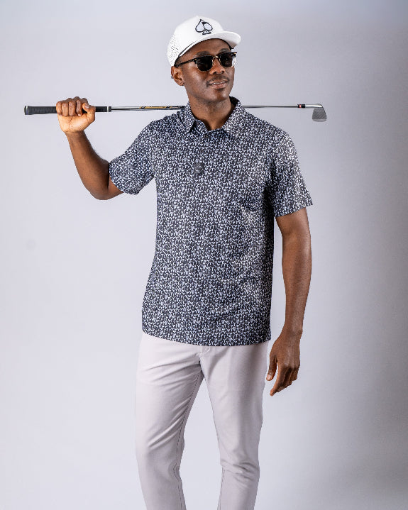 Men’s Shark Tooth golf polo by Pins & Aces featuring an all-over black, charcoal, gray, and white shark tooth-inspired micro print with short sleeves and an athletic performance fit.