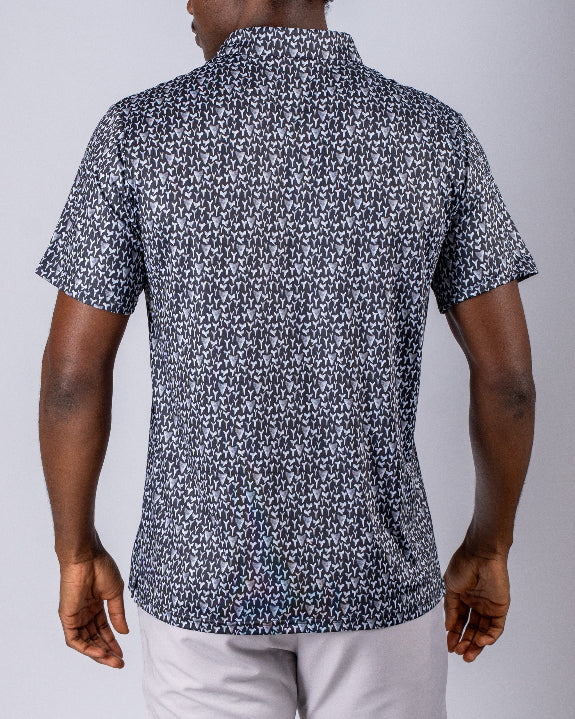 Men’s Shark Tooth golf polo by Pins & Aces featuring an all-over black, charcoal, gray, and white shark tooth-inspired micro print with short sleeves and an athletic performance fit.