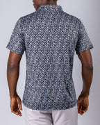Men’s Shark Tooth golf polo by Pins & Aces featuring an all-over black, charcoal, gray, and white shark tooth-inspired micro print with short sleeves and an athletic performance fit.