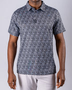 Men’s Shark Tooth golf polo by Pins & Aces featuring an all-over black, charcoal, gray, and white shark tooth-inspired micro print with short sleeves and an athletic performance fit.