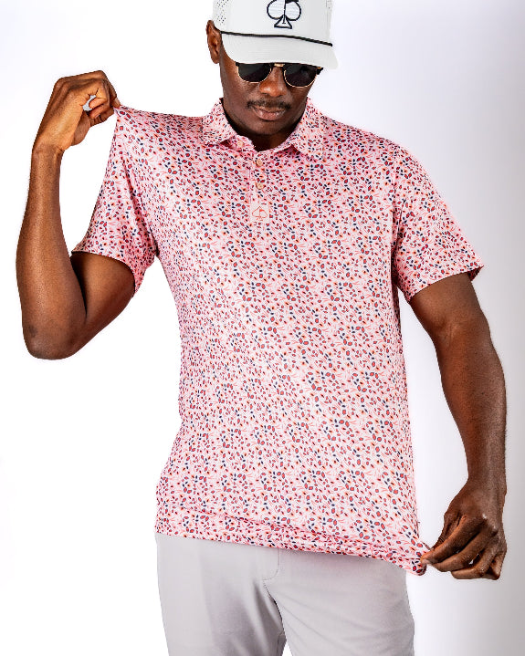 Men’s Soft Spoken golf polo by Pins & Aces featuring a subtle coral, red, navy, and white micro floral print with short sleeves and an athletic performance fit.
