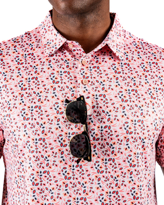 Men’s Soft Spoken golf polo by Pins & Aces featuring a subtle coral, red, navy, and white micro floral print with short sleeves and an athletic performance fit.