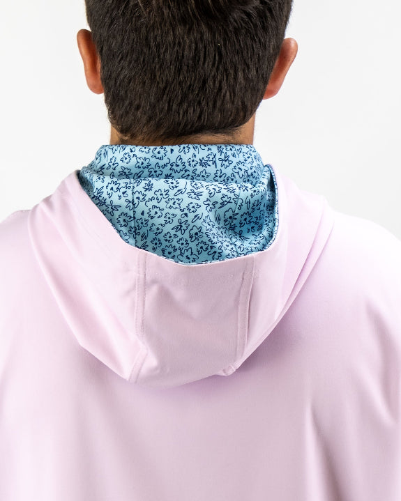 Men’s Flower Doodle Blue performance golf hoodie by Pins & Aces featuring a light pink body, blue floral doodle printed hood interior, embroidered spade logo, and long sleeves.