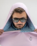 Men’s Flower Doodle Blue performance golf hoodie by Pins & Aces featuring a light pink body, blue floral doodle printed hood interior, embroidered spade logo, and long sleeves.