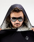 Men’s White Noise Performance Golf Hoodie by Pins & Aces featuring a black lightweight stretch body, embroidered spade chest logo, long sleeves, and White Noise printed hood lining.
